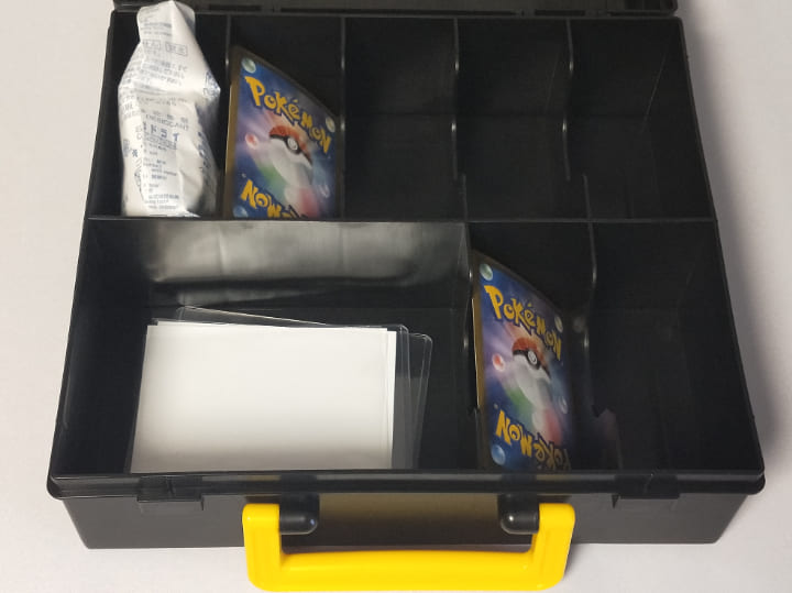 ポケモンカードゲームのキャリングケース ピカチュウVer.2の使い方。乾燥剤と反っているカード・スリーブと硬質ケースが入っている。